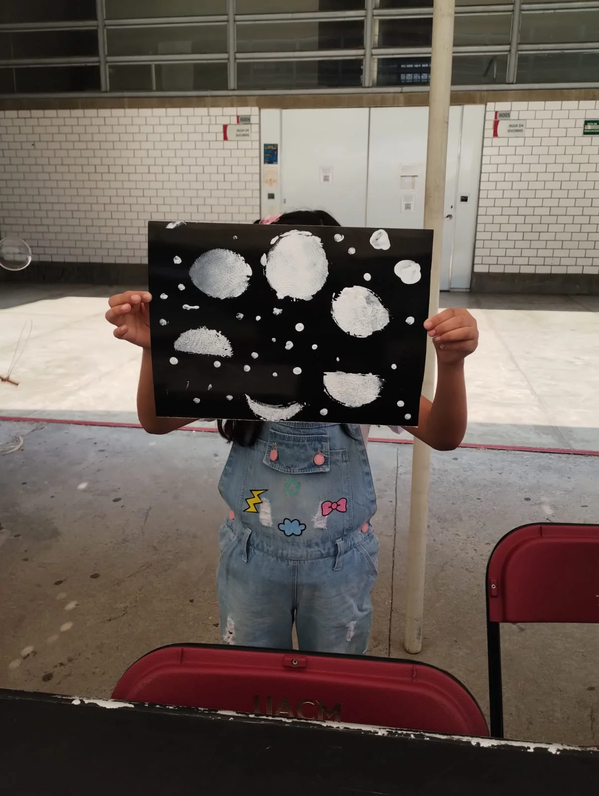 Participante mostrando una lámina con figuras astronómicas.