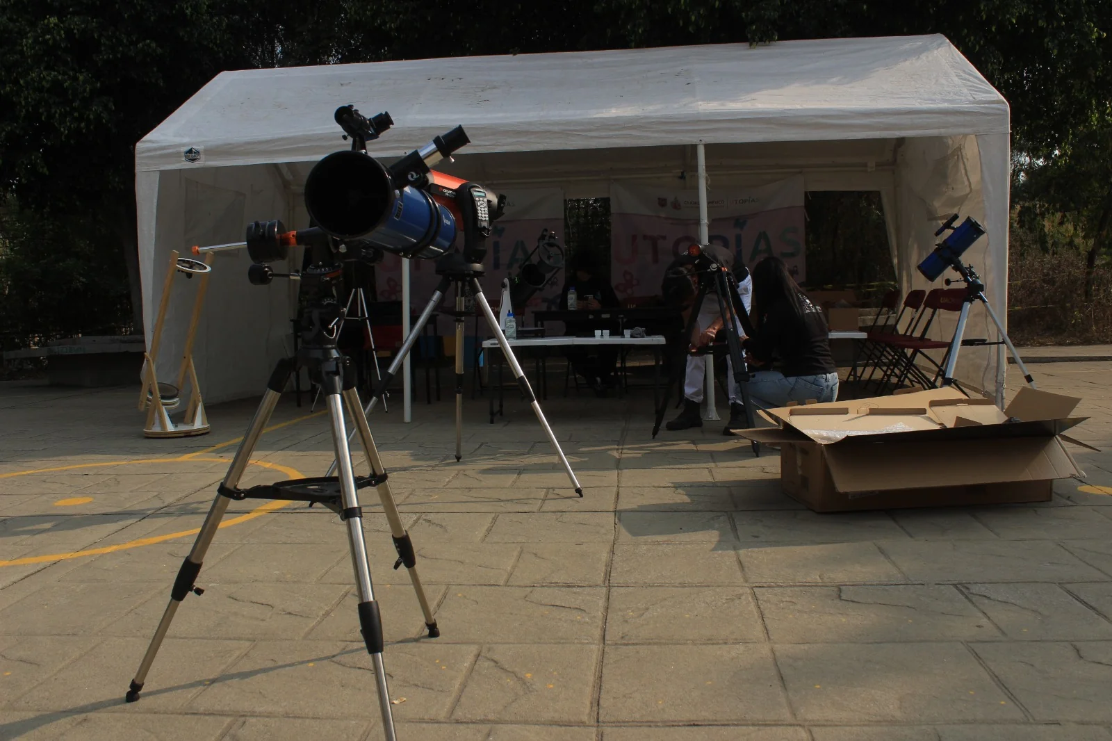 Telescopio instalado frente a una carpa de actividades.
