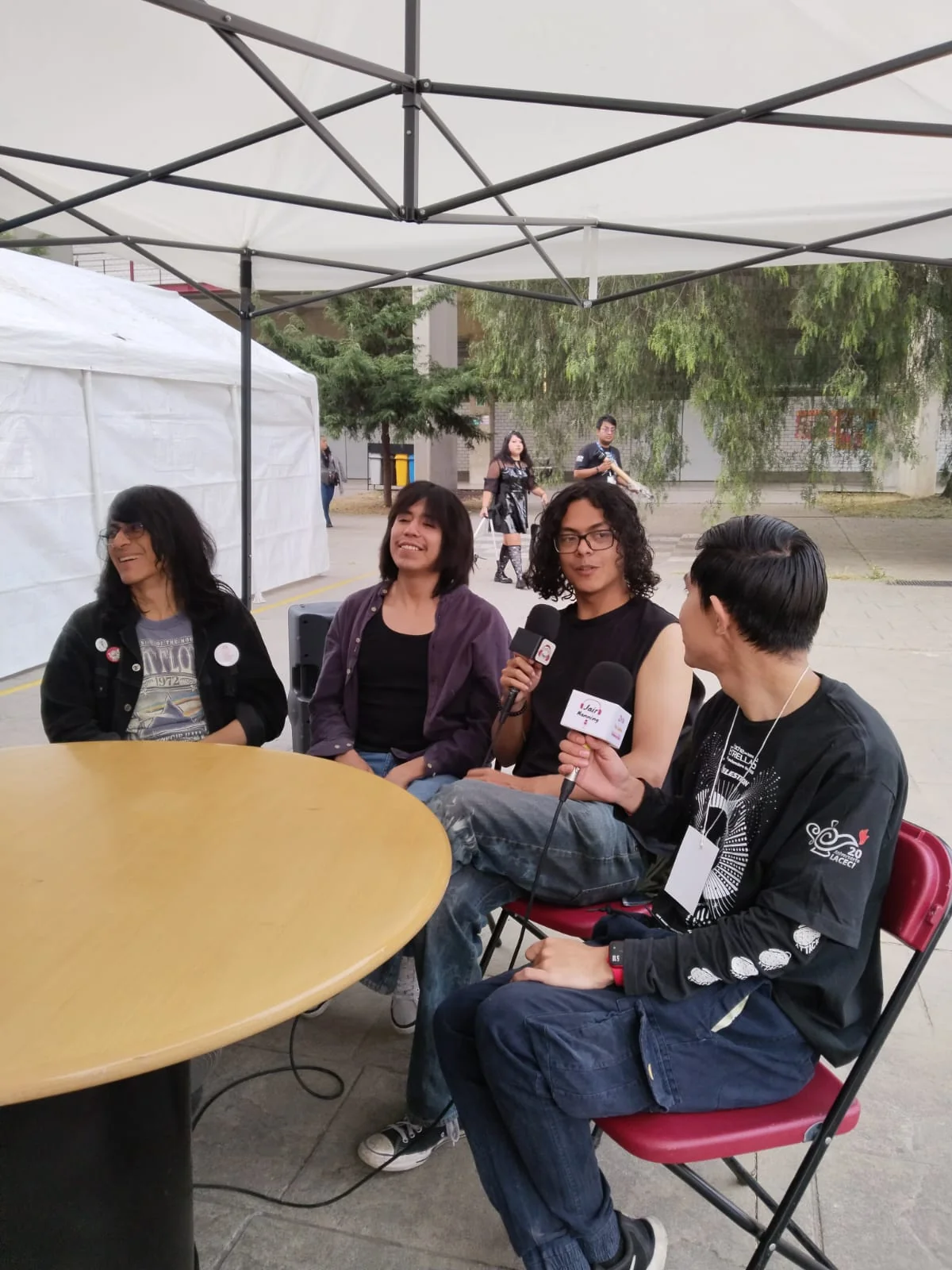 Conversación entre participantes bajo una carpa.